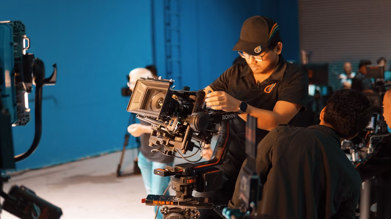 فريق تصوير يجهّز كاميرا سينمائية في موقع تصوير.